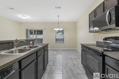 A kitchen with black cabinets and granite countertops.