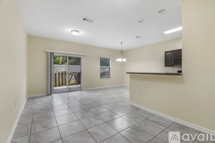 A spacious room with a tiled floor and a bar area.