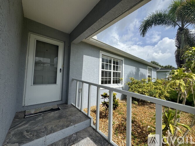 A balcony with a white railing and a glass door.