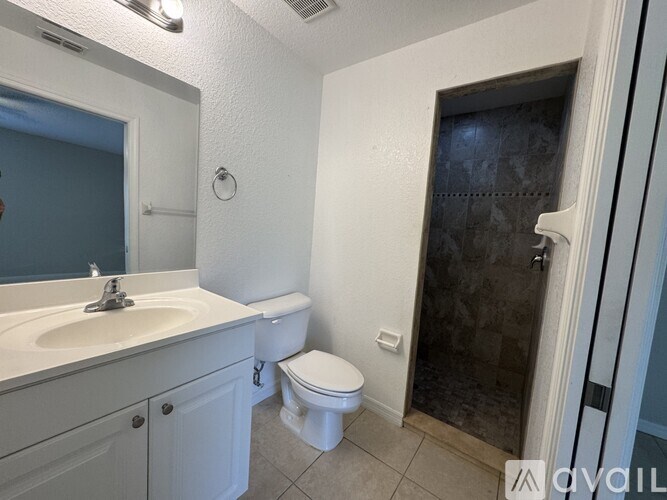 A white bathroom with a toilet, sink, and shower.