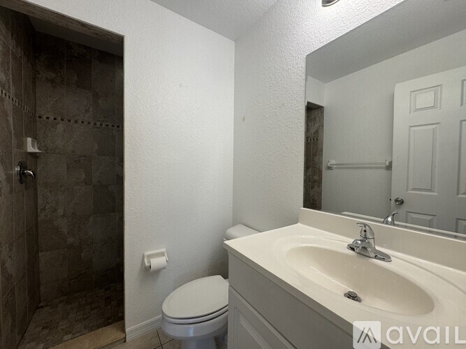 A bathroom with a toilet, sink, and shower.