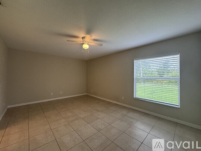 A room with a ceiling fan and a window with blinds.