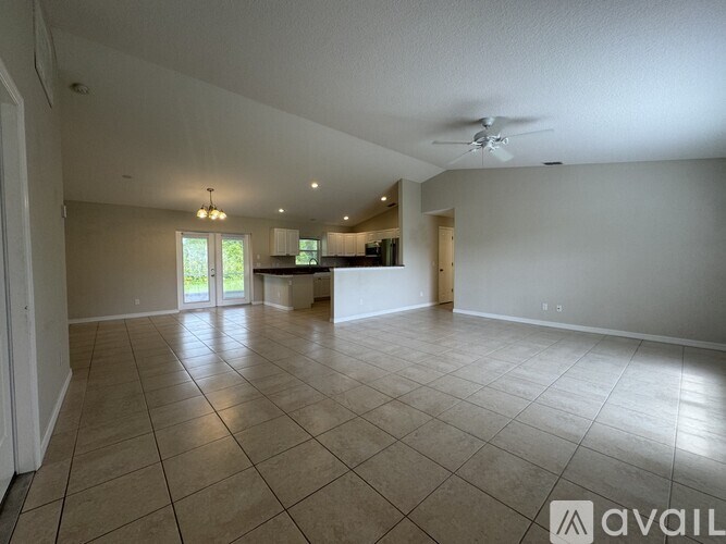 A spacious room with tiled flooring and a ceiling fan.