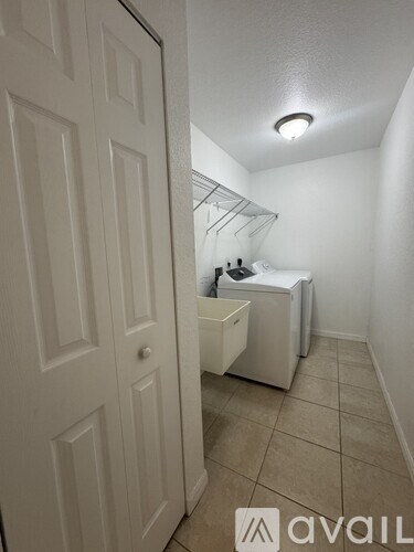 A white door is open to a small bathroom with a toilet and sink.