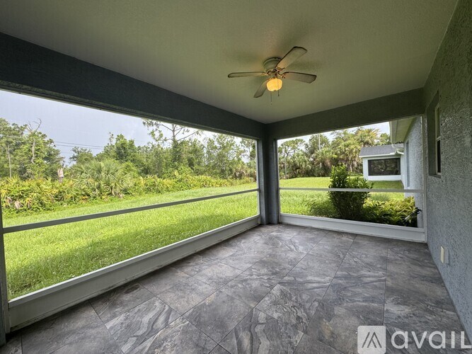 A sunroom with a ceiling fan and sliding glass doors.