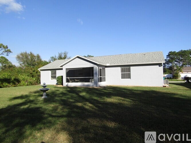 A white house with a grey roof and a white fence.