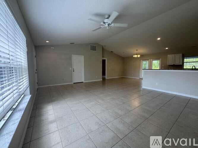 A spacious room with a ceiling fan and tiled flooring.