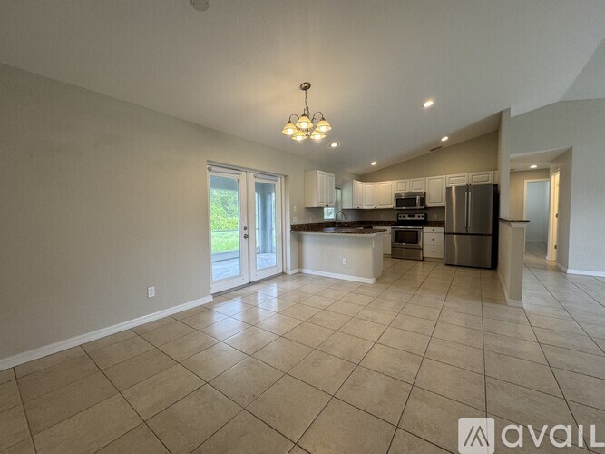 A spacious kitchen and living room with a tiled floor and a large island.