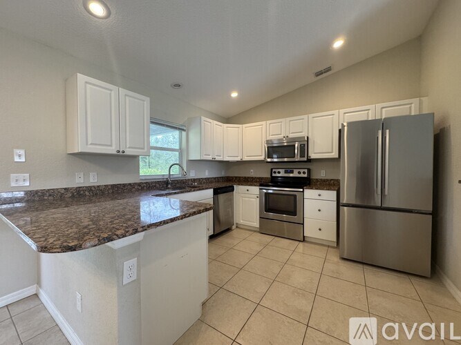 A kitchen with granite countertops and stainless steel appliances.