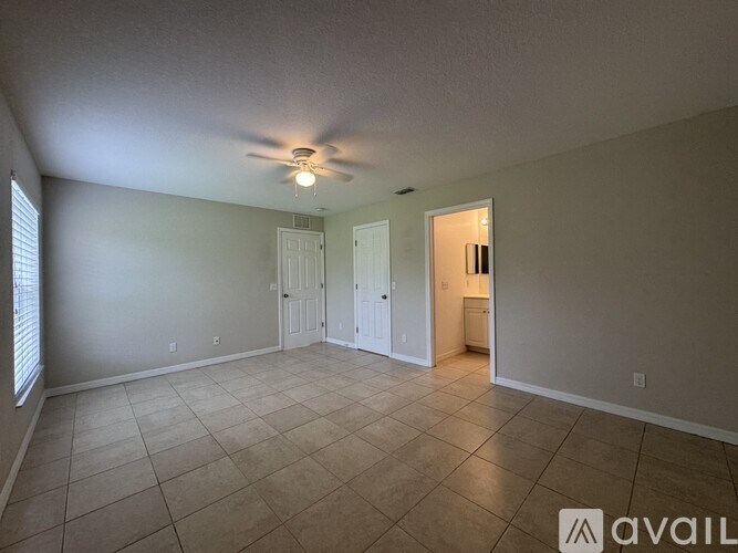 A spacious room with a ceiling fan and tile flooring.