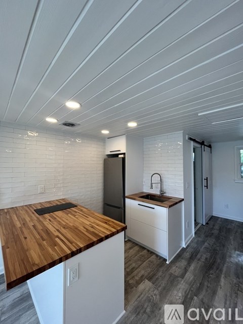 A kitchen with a wooden counter top and white cabinets.