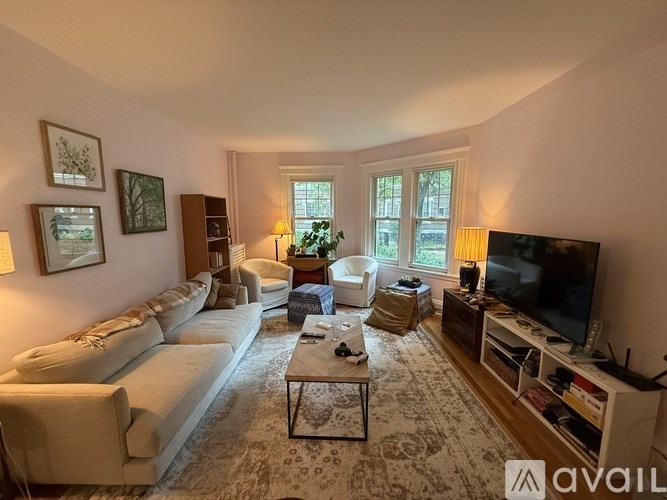 A living room with a white sofa, a coffee table, and a television.