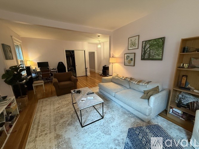 A living room with a white couch, a coffee table, and a rug.