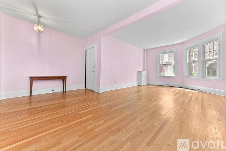 A room with pink walls and wooden flooring is available for rent.