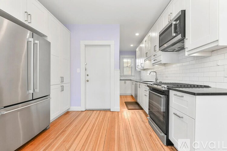 A kitchen with a refrigerator, oven, and microwave.