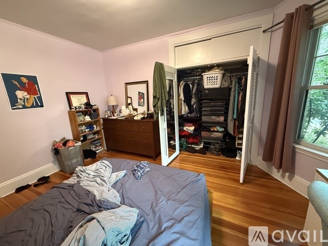 A bedroom with a bed, a wardrobe, and a window.