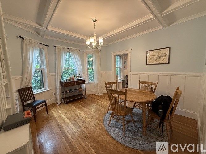 A dining room with a wooden table and chairs.