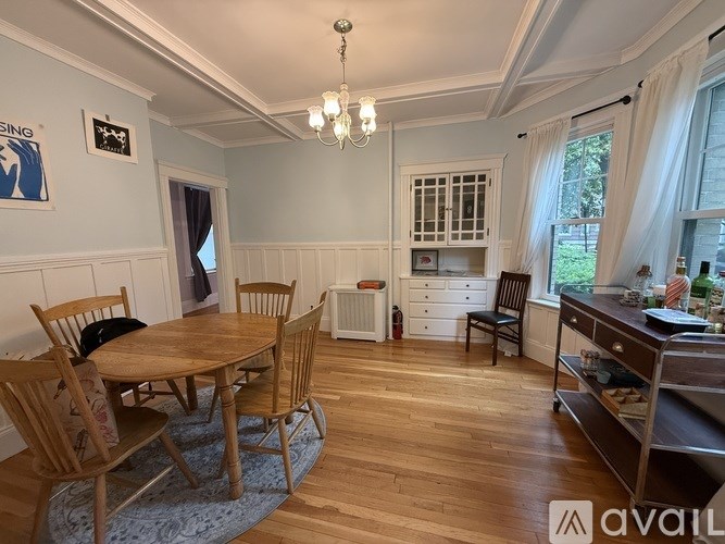 A dining room with wooden chairs and a table.