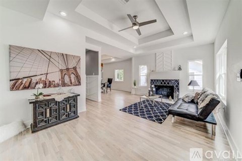 A spacious living room with a fireplace and a large painting on the wall.