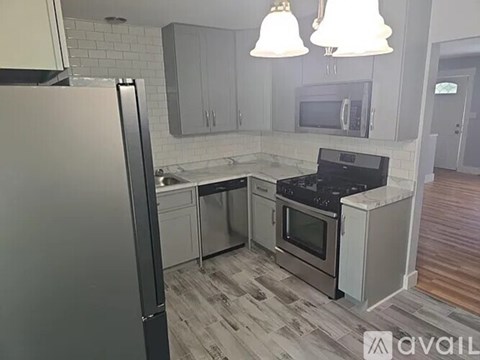 A kitchen with a black stove top oven and a white refrigerator.