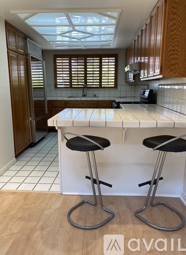A kitchen with a bar stool in front of a counter.