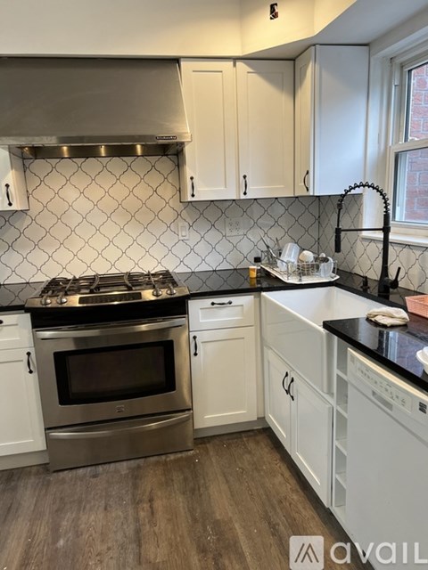 A kitchen with a stove top oven and a range hood.