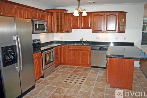 A kitchen with wooden cabinets and a tiled floor.