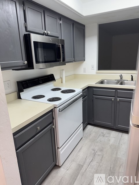 A kitchen with a white stove top oven and a white dishwasher.