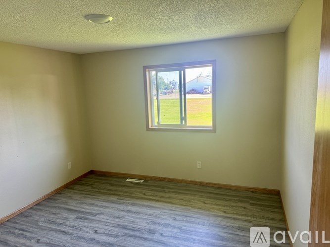 A room with a window and wooden flooring is available for rent.