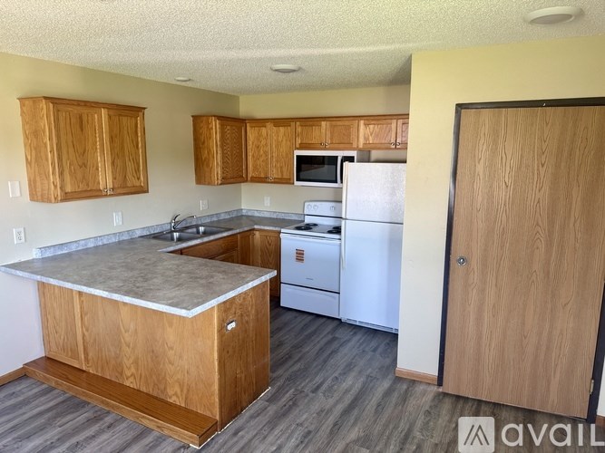 A kitchen with wooden cabinets and a white refrigerator.
