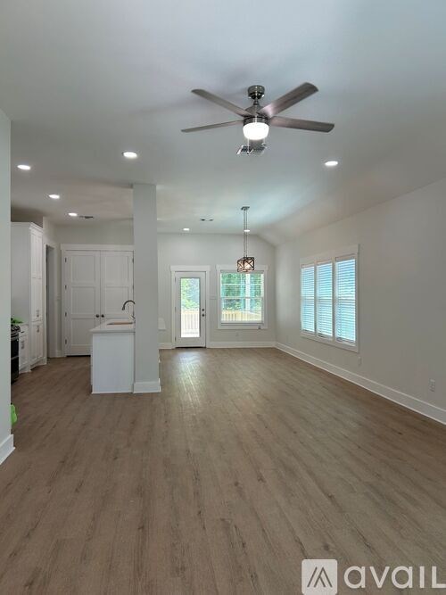 A spacious room with a ceiling fan and lighting fixtures.