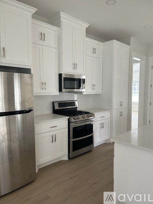A kitchen with white cabinets and stainless steel appliances.