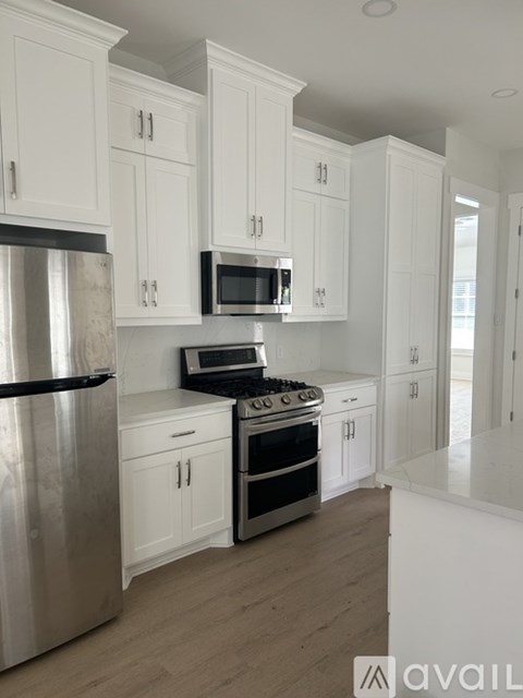A kitchen with white cabinets and stainless steel appliances.