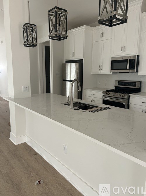 A kitchen with white cabinets and a white countertop.