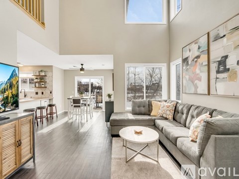 A modern living room with a grey sofa and a wooden coffee table.