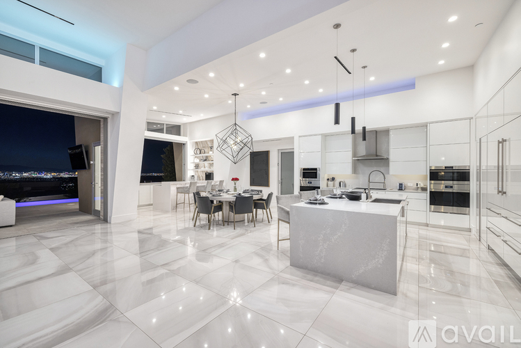 A modern kitchen with a dining table set up in the middle.