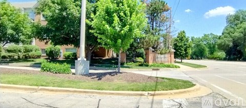 A street view with a building and trees.