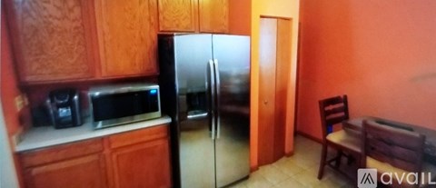 A kitchen with wooden cabinets and a refrigerator.