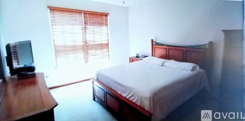 A bedroom with a bed, nightstand, and television.