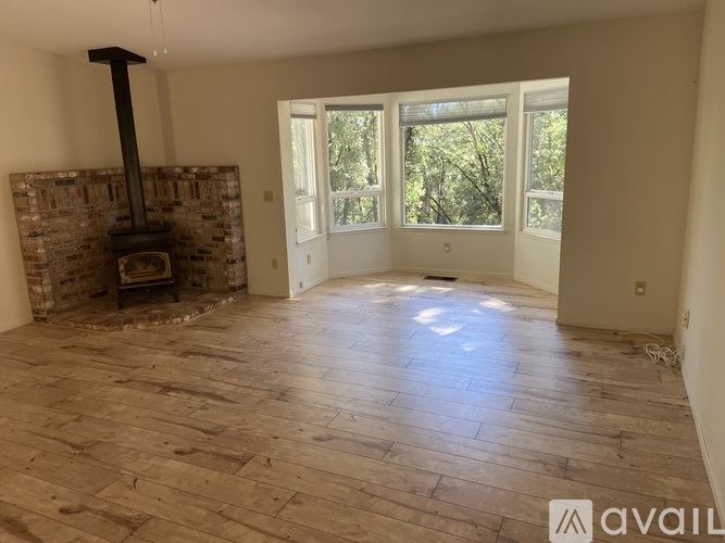 A room with a wood burning stove and a large window.