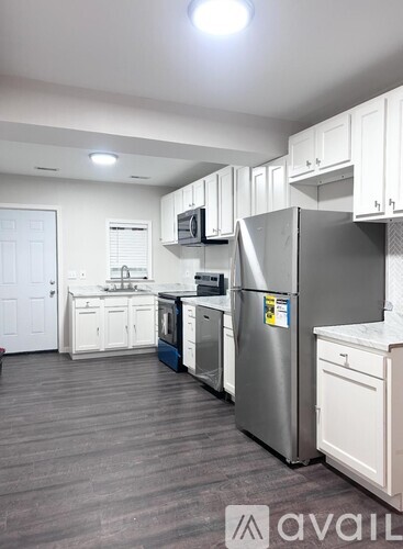 A kitchen with a refrigerator, microwave, and oven.