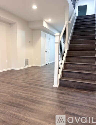 A staircase with a wooden floor and white railings.