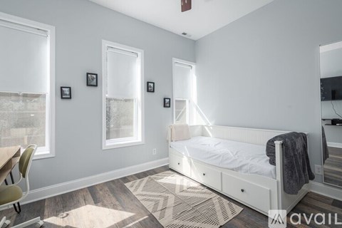 A bedroom with a bed, chair, and pictures on the wall.