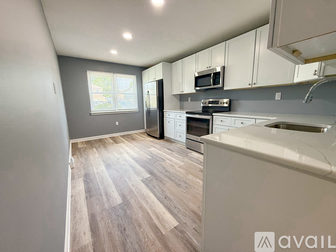 A kitchen with a white counter and a grey floor.