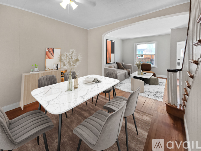 A modern dining room with a white marble table and grey chairs.