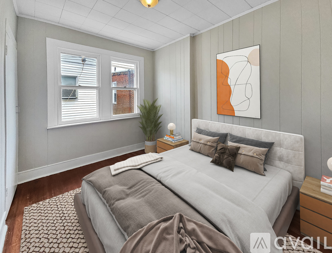 A bedroom with a large bed and a painting on the wall.