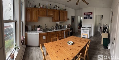 A kitchen with wooden cabinets and a dining table with chairs.