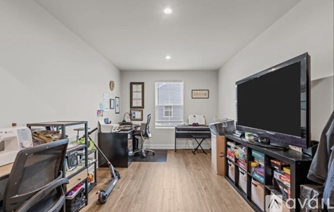 A living room with a black television on the right side.