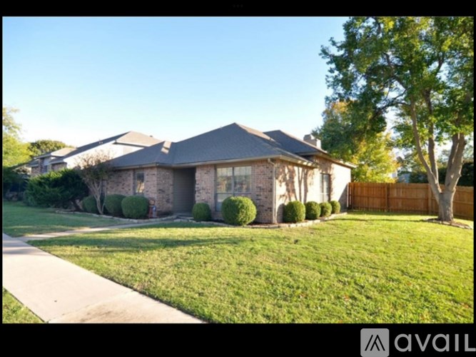 A house with a well-maintained lawn and a clear sky.