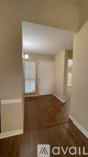 A bedroom with a large bed, a ceiling fan, and a window with blinds.